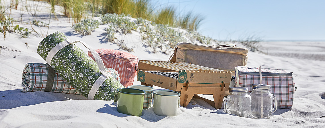 Toalha de praia, manta de praia e outro equipamento de picnic para uma viagem à praia