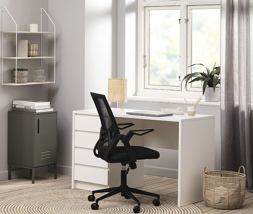 White desk with table lamp, office chair and wastepaper bin in office 