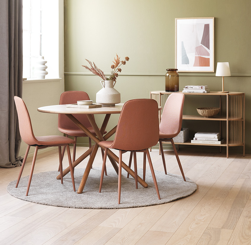 Cadeiras de jantar coral à volta de uma mesa de jantar redonda na sala de estar  
