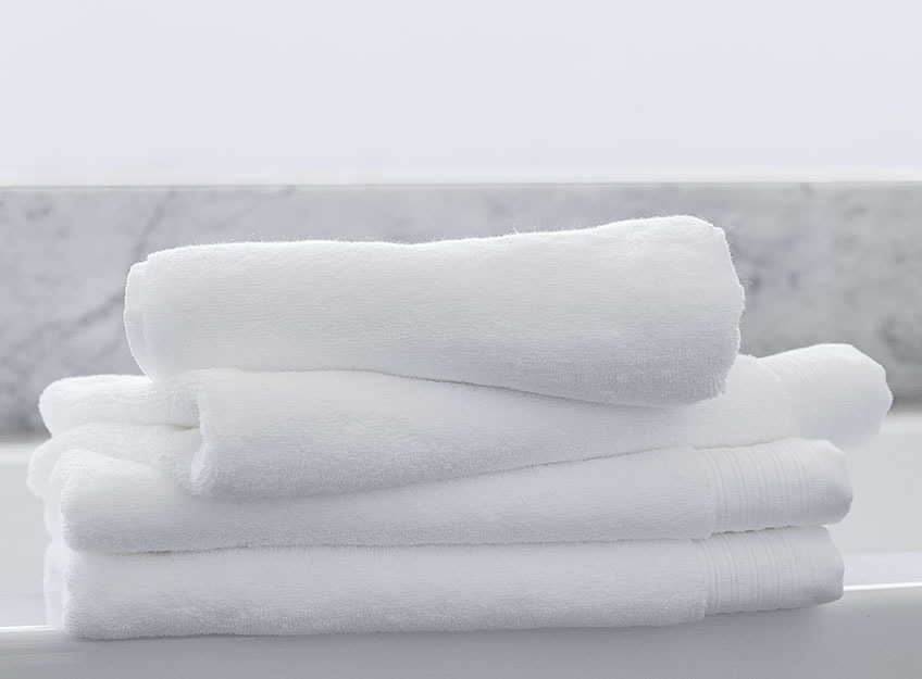 Toalhas brancas empilhadas numa casa de banho
