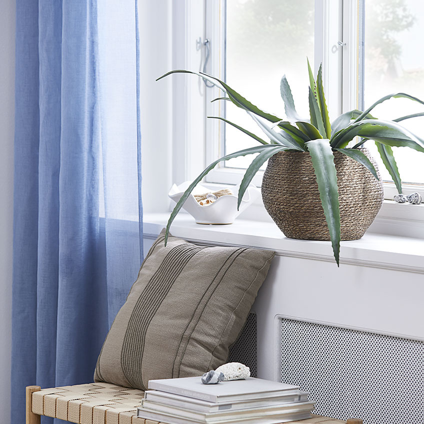 Peitoril de janela com planta artificial num vaso de vime