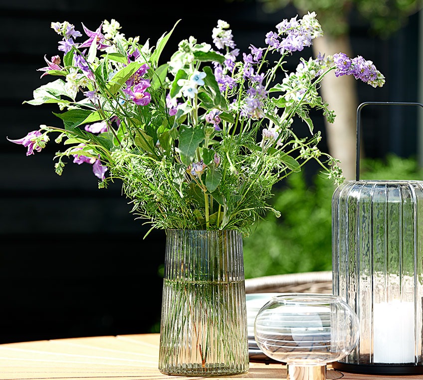 Vaso de vidro numa mesa de jardim
